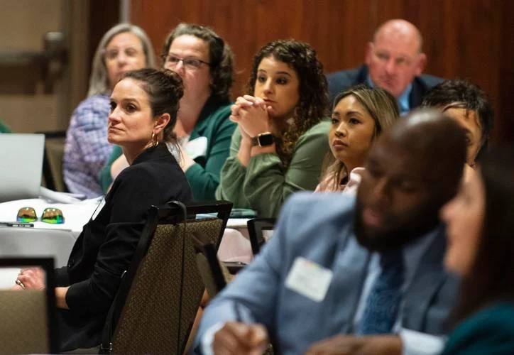 Group of people sitting at a table in a conference hall